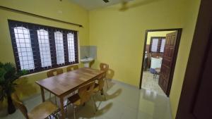a dining room with a table and chairs and a mirror at Yara Homes in Cochin
