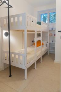 two white bunk beds in a room with a lamp at Pini al Mare in Monterosso al Mare