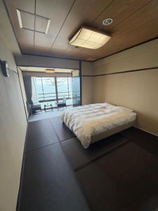 a bedroom with a bed in a room with a window at HOTEL&RESORT Izu no Ne in Higashiizu +32 photos