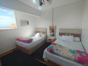 a bedroom with two beds and a window at luxurious direct seaview apartment in Alexandria