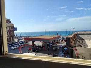a view from a window of a gas station near the ocean at luxurious direct seaview apartment in Alexandria
