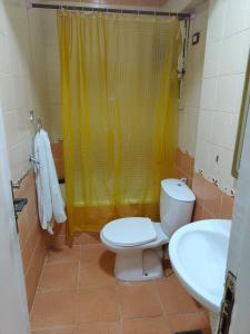 a bathroom with a toilet and a yellow shower curtain at luxurious direct seaview apartment in Alexandria +11 photos
