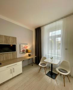 a living room with a tv and a table and chairs at Pension Phoenix in Znojmo