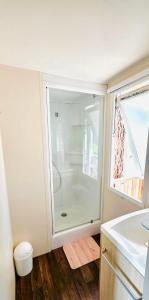 a bathroom with a shower and a sink at Mobil home 3 chambres - Homair parc des 7 fonts 3 étoiles in Agde +4 photos