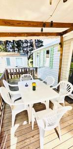 a white table and chairs on a wooden deck at Mobil home 3 chambres - Homair parc des 7 fonts 3 étoiles in Agde