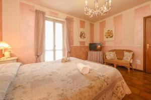 a bedroom with a large bed and a chandelier at Relais De La Place - Downtown in Desenzano del Garda