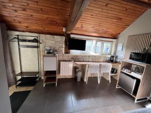 a kitchen with a table and a tv in a room at Chambre à la campagne la ch tite bauquerie in Commes