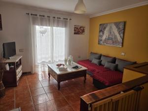 a living room with a red couch and a table at Casa Cielito Lindo in Las Eras