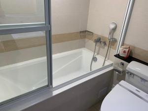 a bathroom with a bath tub and a toilet at Eastin Taipei Hotel in Taipei