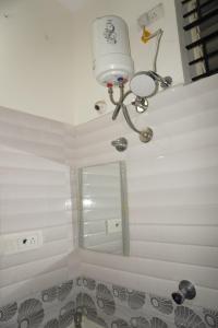 a bathroom with a ceiling light and a mirror at Brindavana Stay in Bangalore