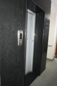 a elevator in an office with a black wall at Brindavana Stay in Bangalore