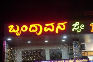 a neon sign on the side of a building at Brindavana Stay in Bangalore