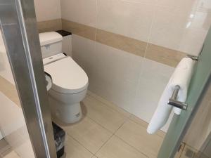 a small bathroom with a toilet and a towel at Eastin Taipei Hotel in Taipei