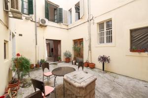 a patio with a table and chairs and a building at Apartment Poluotok in Zadar