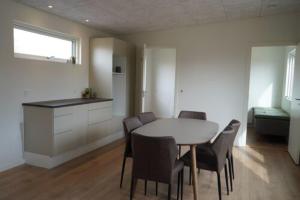 a kitchen and dining room with a table and chairs at Feriehusene Hedensted Centret - Sport, natur og velvære in Hedensted - Midtjylland