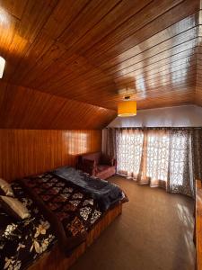 a bedroom with a bed and a couch in a room at Mistvale Cottage in Manāli