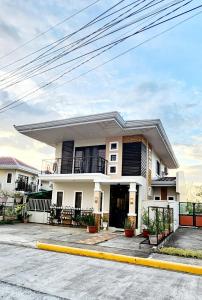 a white house with a yellow curb at Bohol Ramyer Villa in Totolan