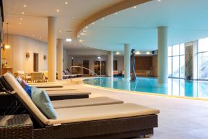 a hotel lobby with a swimming pool and a building at THE GRAND Ahrenshoop in Ahrenshoop