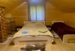 a bedroom with a bed in a wooden cabin at Дідова Хата in Shibeny