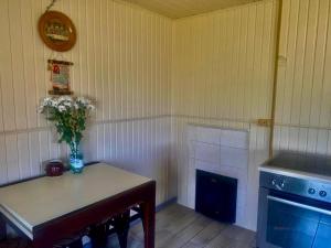 a kitchen with a table with a vase of flowers on it at Дідова Хата in Shibeny