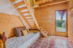 a log cabin bedroom with a bed and stairs at Gîte Le Jardin Mirandou in Raucoules