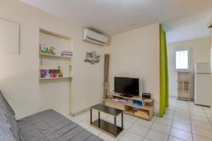 a living room with a tv and a couch at La Colline des Pins in Aniane