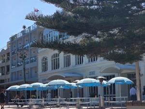 a building with blue and white umbrellas in front of it at Coogee Beach House in Sydney