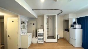 a kitchen with a refrigerator and a microwave at Shinka Hotel Susukino in Sapporo