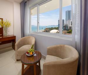 a living room with two chairs and a table and a window at T78 Nha Trang Hotel in Nha Trang