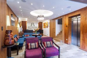 a lobby with a blue couch and purple chairs at Inti Punku Machupicchu Hotel & Suites in Machu Picchu