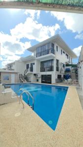 a large house with a swimming pool in front of it at Bohol Ramyer Villa in Totolan