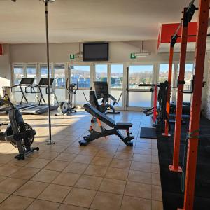 a gym with several treadmills and machines in a room at b apartments in Case Bruciate