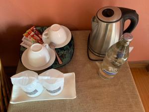 ein Tisch mit einem Teekessel und einer Flasche Wasser in der Unterkunft โรงแรมพิณ in Lampang