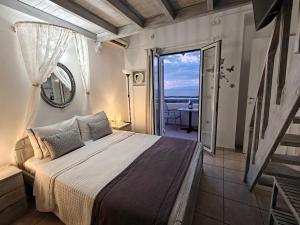 a bedroom with a bed and a view of the ocean at Kiklamino Sunset Suites in Oia +146 photos