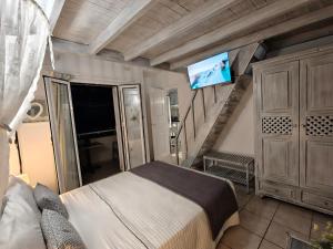 a bedroom with a bed with a flat screen tv at Kiklamino Sunset Suites in Oia