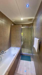 a bathroom with a large tub and a shower at The Oasis Guesthouse in Mtubatuba +47 photos