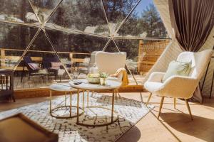 ein Zimmer mit zwei Stühlen und einem Tisch auf einem Balkon in der Unterkunft Skyview Glamping Jacuzzi , Sauna in Ludwinów