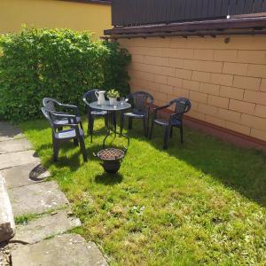 three chairs and a table in the grass at Fair Haven - Dobrej přístav in Lomnice nad Popelkou
