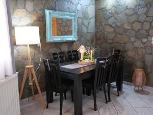 a dining room with a table with chairs and a mirror at D&K Studio in Myrina