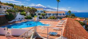 a resort with a swimming pool with a mountain in the background at Teide & Mar Vistas in Tacoronte