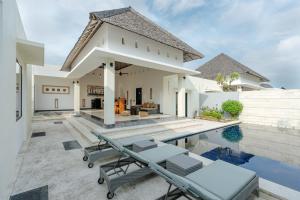 a villa with a swimming pool and a house at The Seminyak Suites Private Villas in Seminyak +40 photos