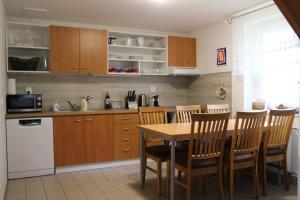 a kitchen with a wooden table and wooden cabinets at Chata Větrník u Černého dolu v Krkonoších in Lauterwasser