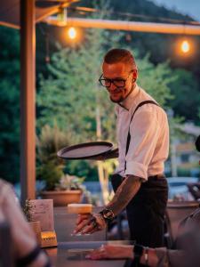 a man standing at a table preparing food at Lodenwirt Residence in Vandoies