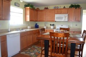 a kitchen with wooden cabinets and a wooden table with chairs at Casa Carmen home in Crystal Beach