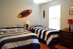 a bedroom with two beds and a surfboard on the wall at Casa Carmen home in Crystal Beach