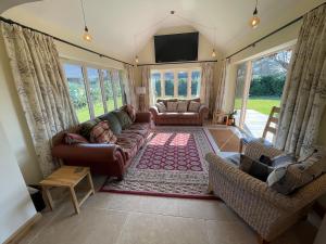 a living room with a couch and a tv at Stocks Lane Cottage in Welshampton