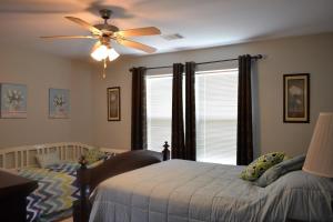 a bedroom with a bed and a ceiling fan at Casa Carmen home in Crystal Beach