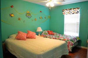 two beds in a bedroom with blue walls and a window at Casa Carmen home in Crystal Beach +14 photos