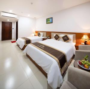 a hotel room with two beds and a couch at T78 Nha Trang Hotel in Nha Trang