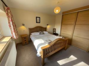 a bedroom with a wooden bed in a room at Stocks Lane Cottage in Welshampton